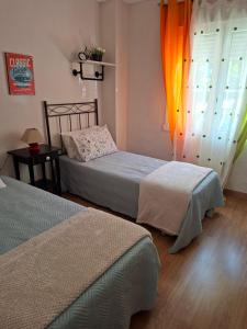 a bedroom with two beds and a window at El Marques 28 by emepas in Logroño
