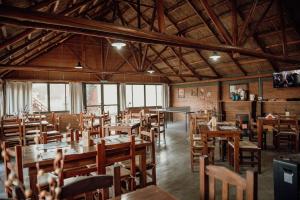 a dining room with wooden tables and chairs at Cantonavi Cabañas in Mina Clavero