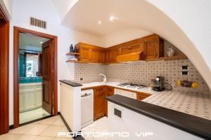 a kitchen with wooden cabinets and a counter top at Greca by PortofinoVip, Seaview, AC in Portofino