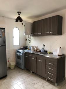 a kitchen with brown cabinets and a sink and a stove at Departamento la Oma in Posadas