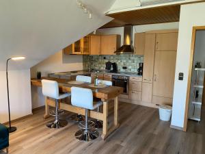 a kitchen with a wooden table and some chairs at Ferienwohnung Niederrhein-Oase in Kevelaer