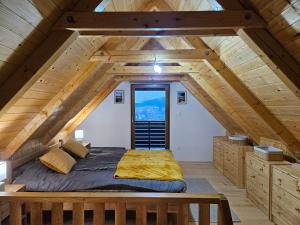 a bed in the middle of a attic bedroom at Cascada Cottage in Barilović