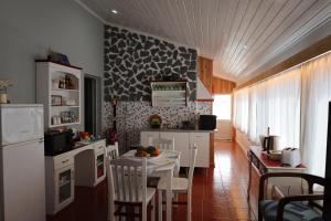 a kitchen with white cabinets and a table with chairs at Casa do Calço in Ponta Delgada