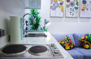a kitchen counter with a stove top oven next to a couch at Luxury One-Bedroom Apt AlRimal-3 in Riyadh