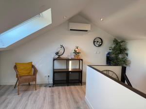 a living room with a staircase and a chair at 70m2 climatisé - Parking privé - Terrasse - 2 chambres - Lycée Roosevelt - Reims Arena in Reims +12 photos