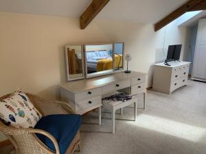 a bedroom with a dresser with a mirror and a bed at 1 bed-cottage-Parking-Patio-close to coasts in North Hill