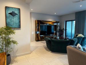 a living room with a couch and a table at Mauritius Rooms - Luxury Beachside Aparthotel Penthouse in Grand Baie
