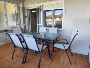 a glass table and chairs on a balcony at Nefeli's cozy apartment afytos in Afitos