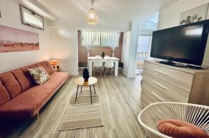 ein Wohnzimmer mit Couch und Flachbildfernseher in der Unterkunft Holibai, Vila Natercia, Horizontes de Galicia, Casa de Piedra y Mar, Baiona in Baiona