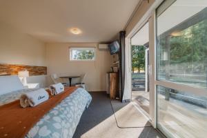 a bedroom with a bed and a sliding glass door at Orion Suite - Compact Stay with Essentials in Lake Tekapo