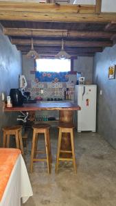 een keuken met een tafel met stoelen en een koelkast bij Chalé do vini in Prado +58 foto's