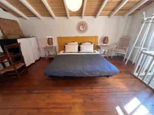 a bedroom with a bed in a room with wooden floors at Aix-en-Provence, Bastidon provençal plein cœur de la forêt avec vue unique in Le Tholonet