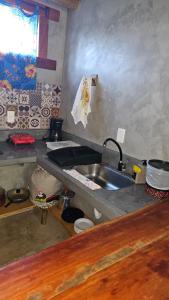 een keuken met een spoelbak en een aanrechtblad bij Chalé do vini in Prado