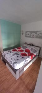 a bedroom with a bed with red roses on it at Detente Caraïbes in Le Gosier