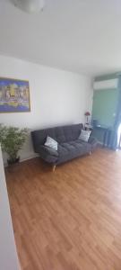 a living room with a couch and a wooden floor at Detente Caraïbes in Le Gosier
