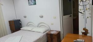 a small bedroom with a bed and a table at Nettuno in Durrës