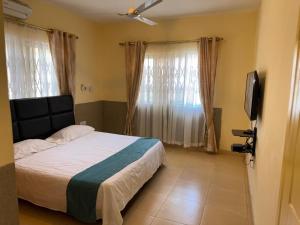 a bedroom with a bed and a flat screen tv at Luxury Tema community 25 gated 3-bedroom house - Fivehills homes in Tema