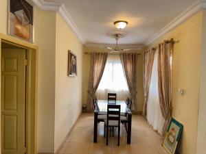 a dining room with a table and chairs and a window at Luxury Tema community 25 gated 3-bedroom house - Fivehills homes in Tema