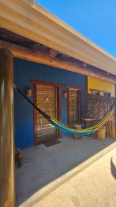 een hangmat aan de zijkant van een huis bij Chalé do vini in Prado