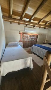 een slaapkamer met twee bedden en een raam bij Chalé do vini in Prado