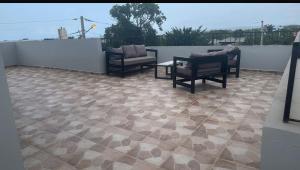 Un patio con sillas y una mesa en un tejado. en Los laureles, en Puerto Plata