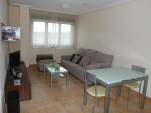 a living room with a couch and a table at Zona Las Catedrales Barreiros Playa de Altar in Villadaíde