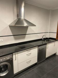 a kitchen with a sink and a washing machine at La Casuca de Corrales in Los Corrales de Buelna +14 photos