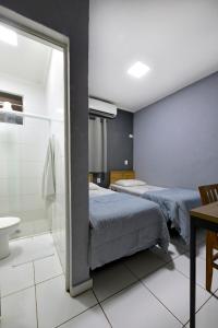 una camera con due letti e una doccia in vetro di HOTEL SENADoR a Ribeirão Preto