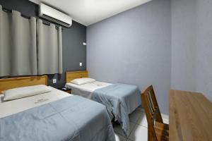 una camera ospedaliera con due letti e un tavolo di HOTEL SENADoR a Ribeirão Preto Altre 44 foto
