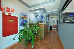 un corridoio con una porta rossa e una pianta di HOTEL SENADoR a Ribeirão Preto
