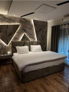 伊斯兰堡Capital Family Guest House的一间卧室，配有一张大床和一堵石墙