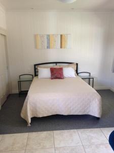 a bedroom with a large white bed with two tables at Horsepower Cabins in Warwick
