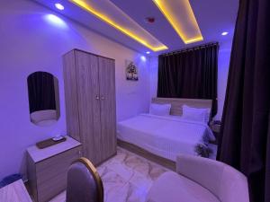 a bedroom with a bed and a tv and chairs at Grand Lynks Homes and Apartments in Gwarinpa +3 photos