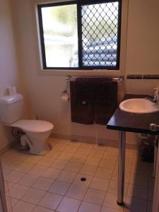 a bathroom with a toilet and a sink and a window at Horsepower Cabins in Warwick +9 photos