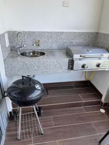 a kitchen counter with a sink and a grill at Apartamento de Descanso Peñazul La Morada in Ricaurte