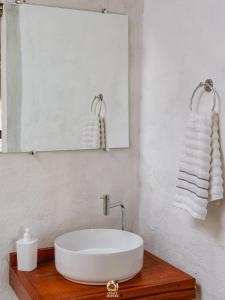 a bathroom with a sink and a mirror and towels at Moitas chalés in Amontada
