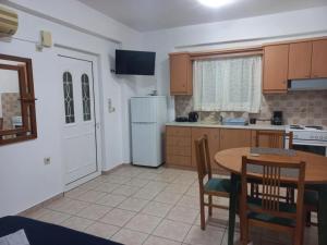 a kitchen with a table and a white refrigerator at Sophie's Sunny Spot 4 in Yéfira +6 photos