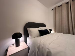 a bedroom with a bed and a lamp on a night stand at Centrally Located Modern 2 Bedroom Apartment, Minutes Walk to AO Arena in Manchester