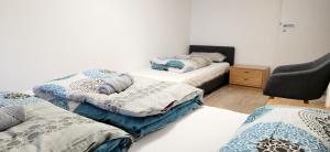 a room with three beds and a chair at Modern apartment im Herzen des Schwarzwald v-s in Villingen-Schwenningen