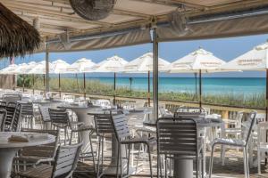 a restaurant with tables and chairs with the beach in the background at Hutchinson Island BeachFront Heated Pool Balcony Top Floor in Jensen Beach