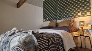 a bedroom with a bed with a blanket on it at Au Gré Des Lis - La Suite Du Chêne in Belval-sous-Châtillon