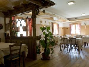 una sala da pranzo con tavoli, sedie e una pianta di Affittacamere Alle Trote a Sùtrio