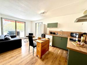 a kitchen and living room with a table and a couch at Petite Calédonie-Clim-Proche mer in La Grande-Motte +16 photos
