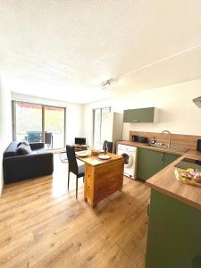a kitchen and living room with a table and a couch at Petite Calédonie-Clim-Proche mer in La Grande-Motte
