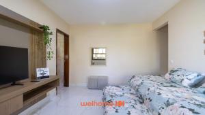 Un dormitorio con una cama y un televisor de pantalla plana. en Apartamento em Miguel Pereira com Varanda Ampla, en Miguel Pereira