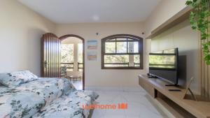 Un dormitorio con una cama y un televisor de pantalla plana. en Apartamento em Miguel Pereira com Varanda Ampla, en Miguel Pereira