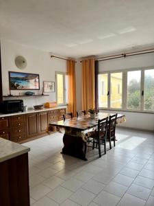 a dining room with a table and chairs in a kitchen at casa solemar in La Maddalena