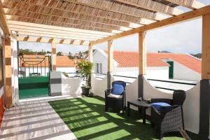 a patio with two chairs and a pergola at Casa do Calço in Ponta Delgada