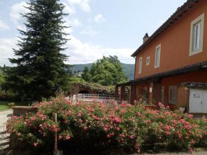 una casa con un árbol y flores delante de ella en Appartamento Cardellini 1, en Pescia