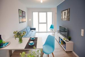 ein Wohnzimmer mit einem blauen Sofa und einem Tisch in der Unterkunft Spreepolis Boardinghaus in Berlin